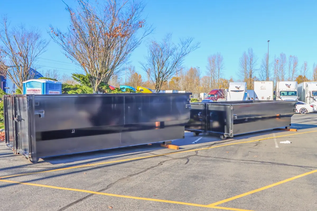 Professional dumpster rental service with roll-off container on residential driveway in Mayfield